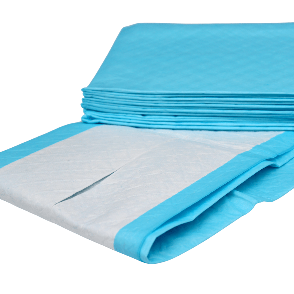 En la imagen se muestra una pila de protectores de cama Altruflock® azules de 60 x 90 cm, «Supersoft» y de «extrema absorbencia» | Paquete (25 unidades) de Altruan, de un solo uso. Uno de los protectores está parcialmente desplegado, de modo que se aprecia la superficie absorbente blanca con bordes azules. Los protectores para la incontinencia parecen estar apilados de forma ordenada unos sobre otros.