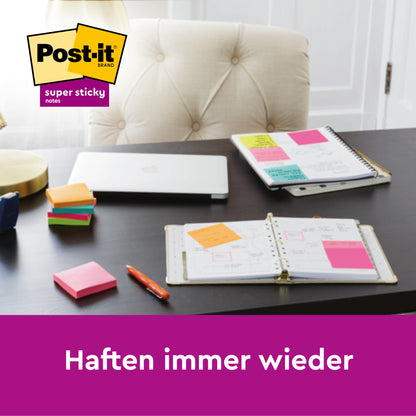 Auf einem Schreibtisch steht ein geschlossener Laptop, aufgeschlagene Notizbücher mit bunten Post-it® Super Sticky Notes im Großformat, Pink, Liniert (101 mm x 152 mm), von 3M Deutschland GmbH. Oben links das Post-it Logo, darunter der Text "Haften immer wieder.