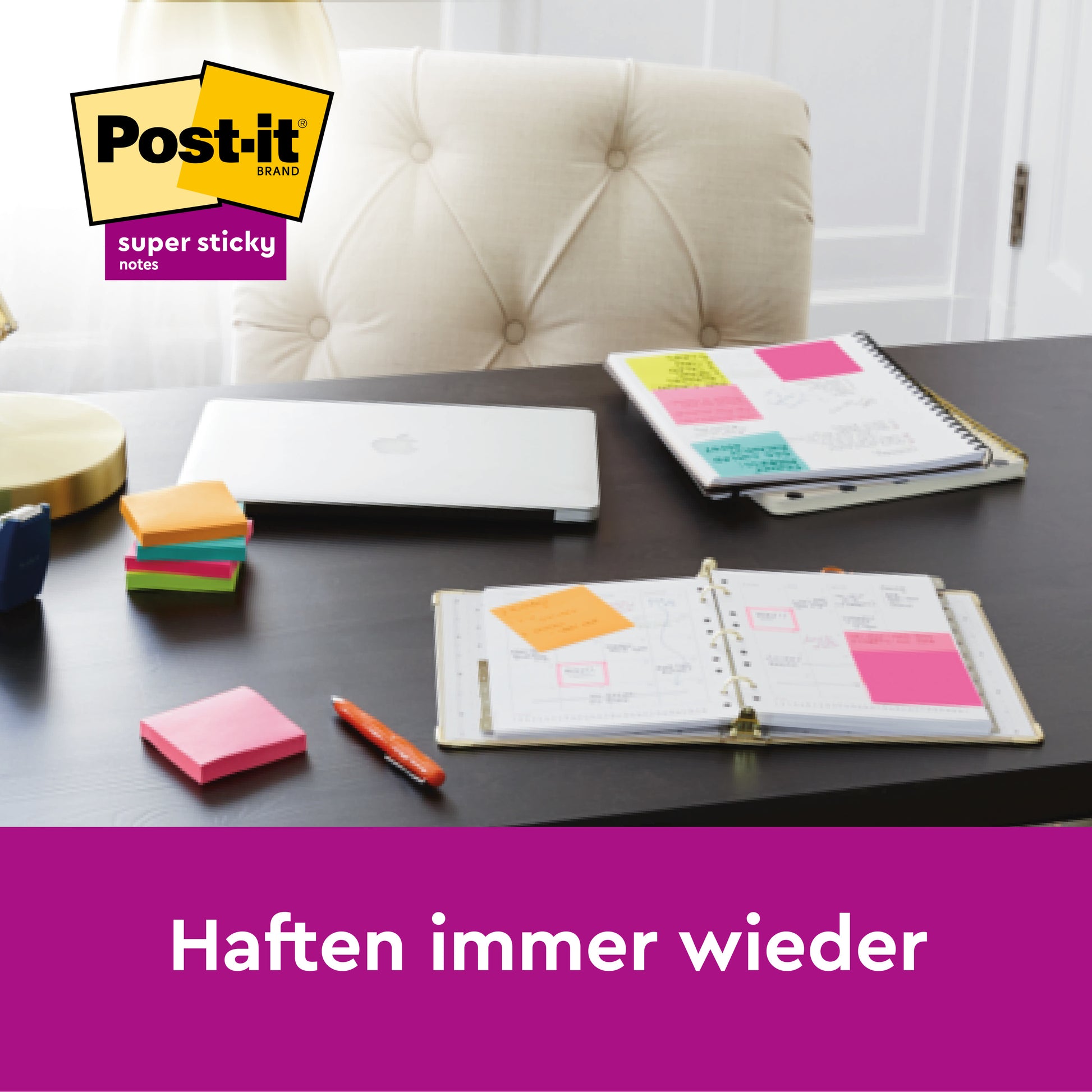 Ein schwarzer Schreibtisch mit einem großen, linierten gelben Post-it® Super Sticky Note (101x101mm, 45 Blatt, 3M Deutschland GmbH), ein aufgeschlagenes Notizbuch, ein Planer mit angehängten Notizen, ein geschlossener Laptop und ein Stift. "Haften immer wieder.