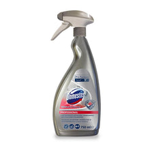 Eine silberne 750-ml-Sprühflasche des DOMESTOS Professional 4in1 Sanitärreinigers der Diversey Deutschland GmbH & Co. OHG steht aufrecht auf einem weißen Hintergrund. Das Etikett zeigt blaue, rote und silberne Produktangaben und Branding.