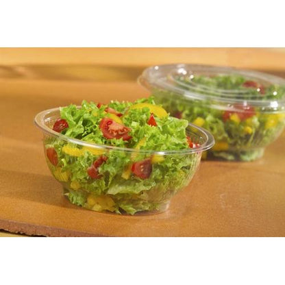 A Starpak 50 salad bowl (R-PET round crystal clear) contains fresh leafy greens, cherry tomatoes, and yellow peppers. In the background, another closed Starpak salad bowl can be seen.