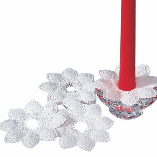 Se pueden ver tres manguitos para velas redondos y blancos PAPSTAR (Ø 10 cm, película): uno envuelto alrededor de una vela cónica roja en un soporte de vidrio, dos acostados - mostrando su diseño elegante y decorativo de PAPSTAR GmbH.