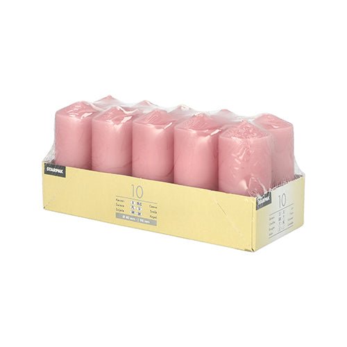 The Starpak 10 pillar candles (Ø 40 mm × 90 mm), pink, are neatly arranged in a transparent plastic container inside an open beige box—perfect for weddings or for creating a cozy atmosphere.