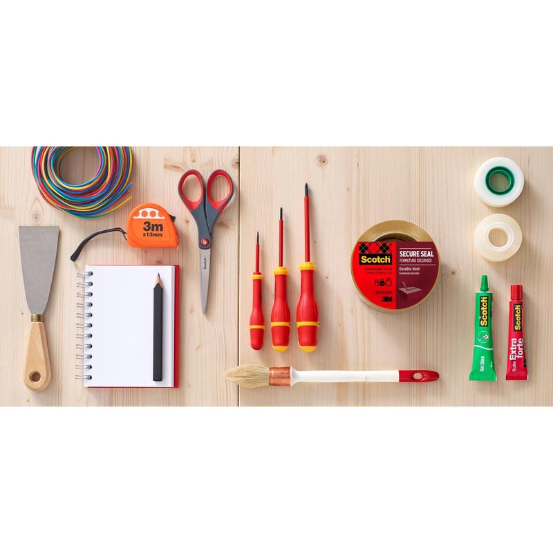 En rull Scotch® emballasjetape (50 mm x 66 m) fra 3M Deutschland GmbH ligger oversiktlig blant håndverktøy og forsyninger på en treflate.