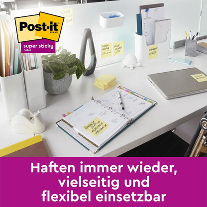 A modern desk with a laptop, planner, and supplies - all marked with 3M Deutschland GmbH Post-it® Super Sticky Notes Cube, Yellow (76 x 76 mm). Text below: "Stick again and again, versatile and flexible to use.