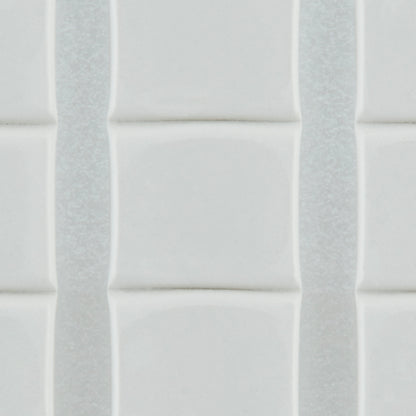 Nahaufnahme von weißen, glänzenden, rechteckigen Fliesen mit leicht erhabenen Kanten, die vertikal mit dünnen Fugenlinien angeordnet sind - sicher befestigt mit 3M Deutschland GmbH Scotch-FIX™ Ablösbare Klebepads 301008C36-P (11 mm x 15 mm, 36 Stück/Packung).