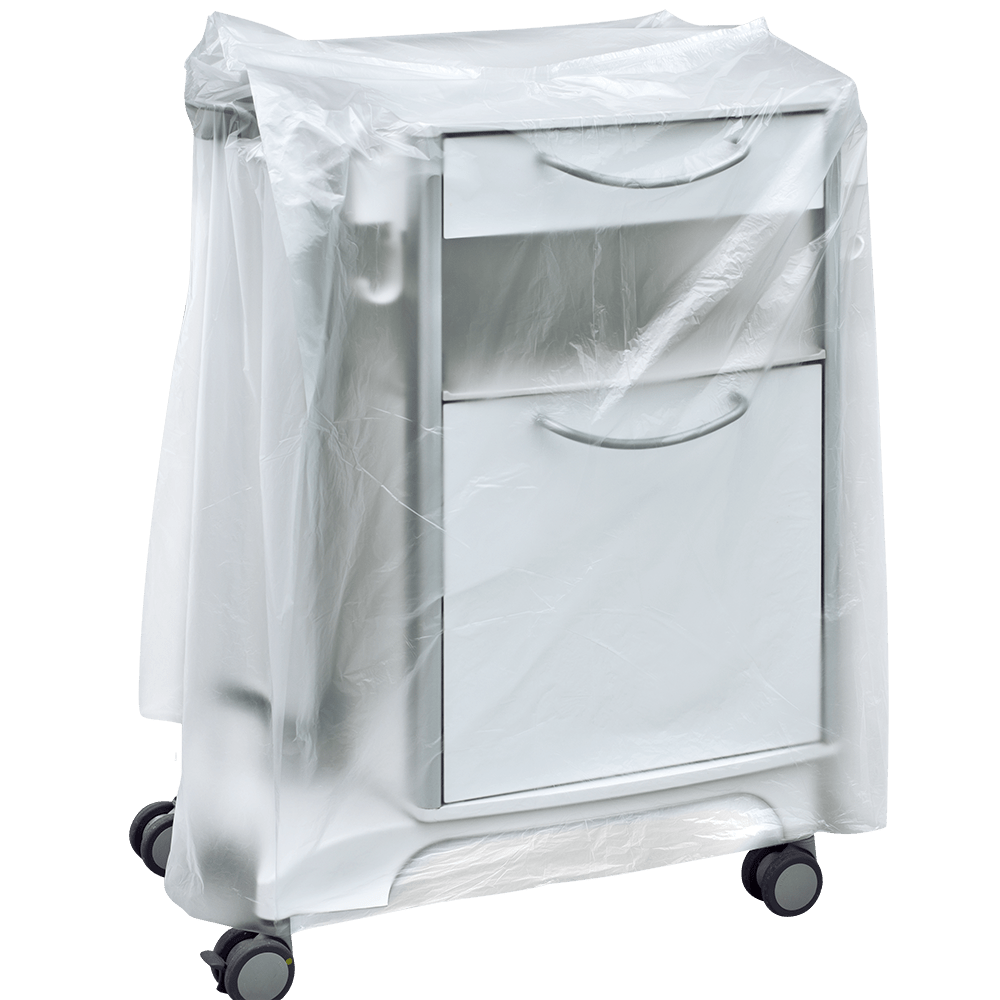 A white medical bedside table on wheels is partially covered with a transparent DEISS 59867 bedside table cover (600+500x1000x0.01 mm) from EMIL DEISS KG, which conceals the drawers and handles. The background is simple and neutral.