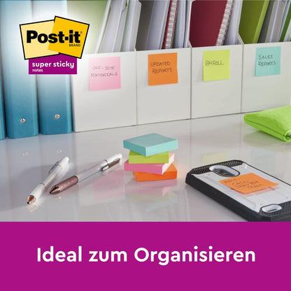 A desk with folders labeled with colorful Post-it® Super Sticky Notes Cubes in Yellow (76 x 76 mm) by 3M Deutschland GmbH, pens, highlighters, and a smartphone on a notepad. Text: "Ideal for organizing.