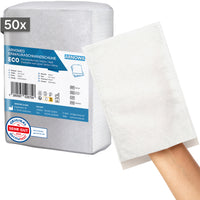 En la imagen se muestra una bolsa con 50 guantes de lavado desechables ARNOMED, fabricados en molton por ARNOWA GmbH. Se lleva un guante en cada mano; al fondo se aprecian el sello de Dermatest y la etiqueta del producto.