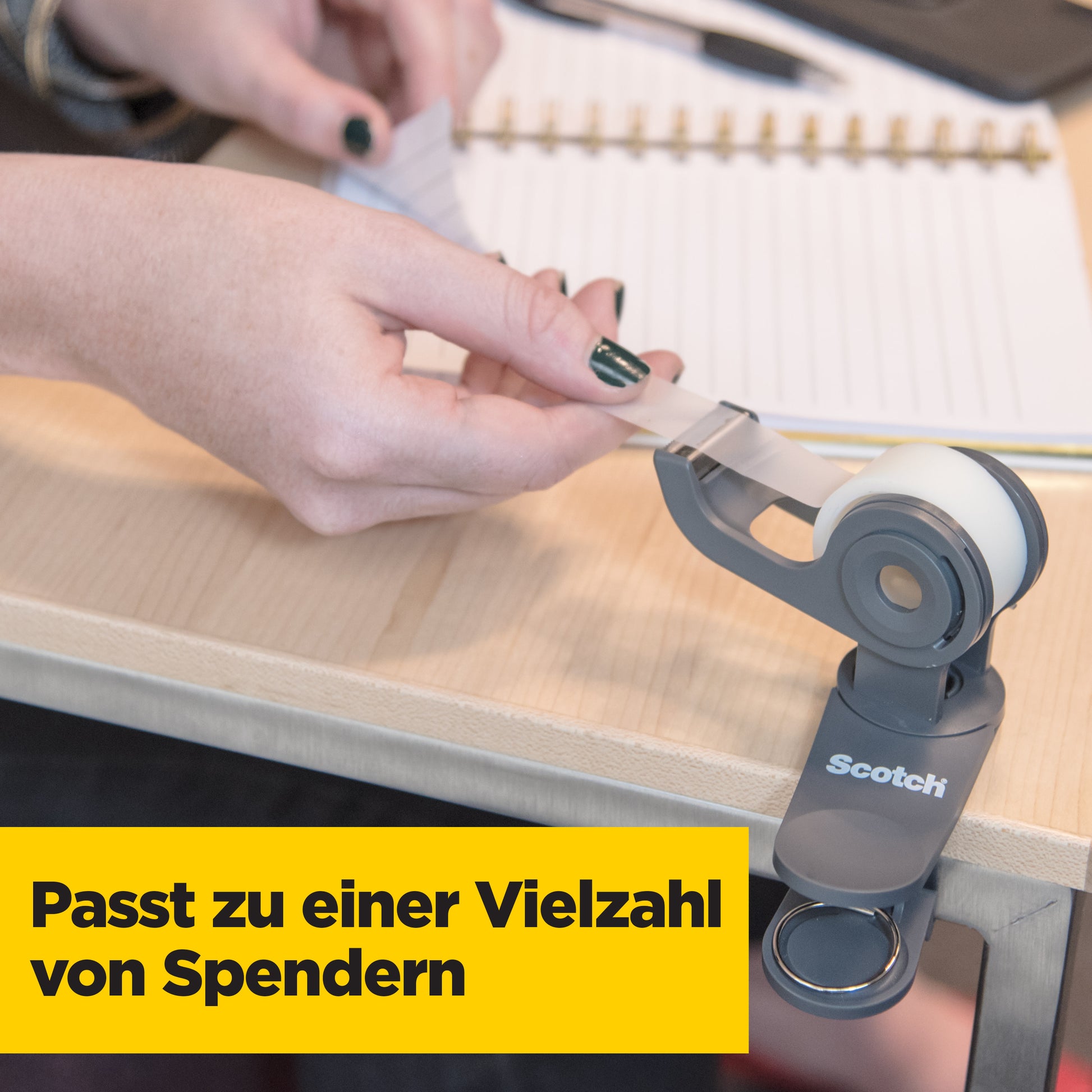Eine Person zieht Scotch® Magic™ Unsichtbares Klebeband aus einem grauen Spender auf einen Holztisch. Im Hintergrund sind Notizbuch und Stift zu sehen. Text: "Passt zu einer Vielzahl von Spendern." Marke: 3M Deutschland GmbH, Vorteilspack 8 Rollen.