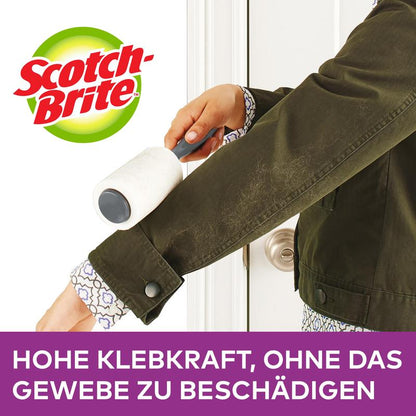 A person uses the Scotch-Brite™ Everyday Clean Mini Lint Roller, 30 sheets, colored handle from 3M Deutschland GmbH on the sleeve of a dark green jacket. Text: "HIGH ADHESIVE STRENGTH, WITHOUT DAMAGING THE FABRIC."