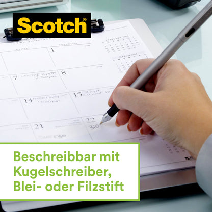 Eine Hand schreibt auf einen Kalender, während der 3M Scotch™ Edelstahl-Klebebandabroller, Silber und Scotch® Magic™ Klebeband (66% pflanzenbasierter Klebstoff) danebenliegt. Unten steht: "Beschreibbar mit Kugelschreiber, Blei- oder Filzstift.