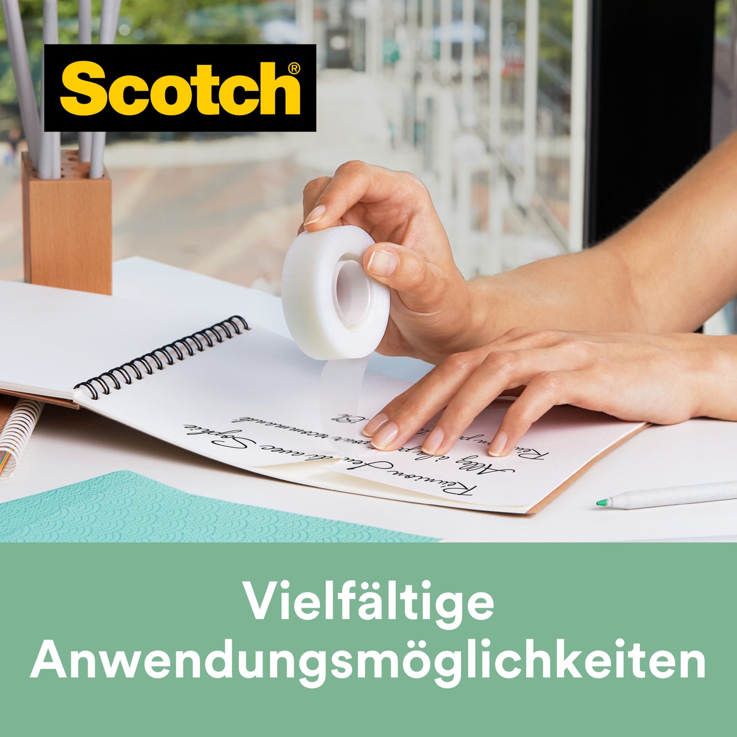 Eine Person hält eine Rolle Scotch® Magic™ Klebeband (19 mm x 33 m, 14 Rollen/Packung, 66 % pflanzlichem Klebstoff) von 3M über einem Notizbuch. Text: "Vielfältige Anwendungsmöglichkeiten." GRATIS Abroller C38, Schwarz.
