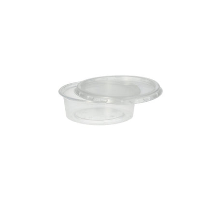 A Starpak 50 dressing cup, PP round Ø 7.1 cm transparent with a matching clear lid is slightly tilted on a plain white background - ideal for catering service.