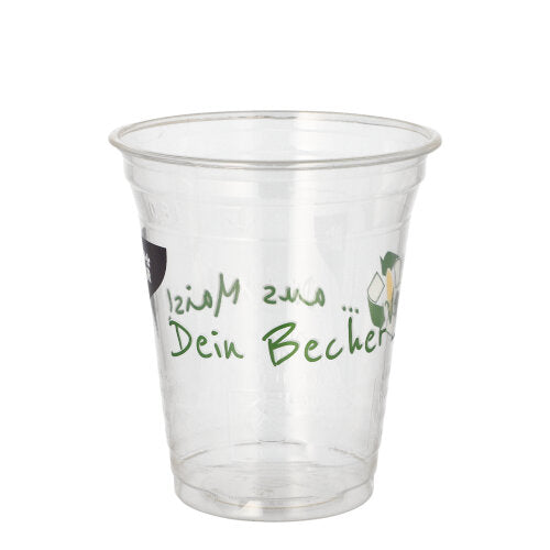A transparent PAPSTAR 50 PLA drinking cup "Cup made of corn" from PAPSTAR GmbH with green "Your cup" lettering on the side is seen empty against a plain white background.