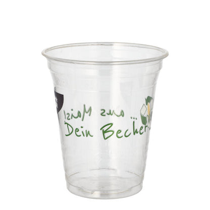 A transparent PAPSTAR 50 PLA drinking cup "Cup made of corn" from PAPSTAR GmbH with green "Your cup" lettering on the side is seen empty against a plain white background.