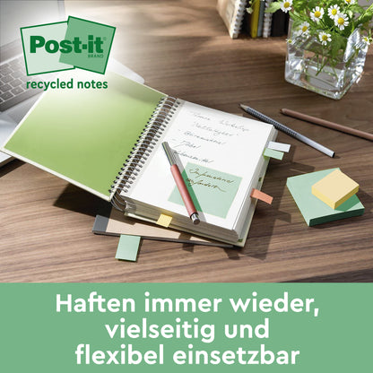 Auf dem Schreibtisch: ein aufgeschlagenes Notizbuch mit einer grünen Post-it® Recycling Notiz (76x76 mm, 100 Blatt, 100% PEFC, von 3M Deutschland GmbH), ein Stift, gestapelte Post-it Notizen, Büroklammern, Bleistift, Tastatur & Glasvase mit Grünpflanzen. Abgebildeter deutscher Text.