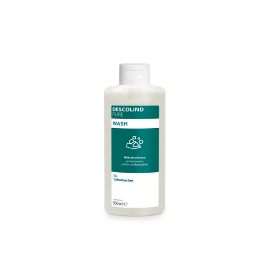 Una botella de plástico blanca de la loción limpiadora Dr. Schumacher Descolind Pure Wash (500 ml), de Dr. Schumacher GmbH, con una etiqueta verde y blanca, se encuentra sobre un sencillo fondo gris claro. Esta loción limpiadora, sin perfume y con un pH neutro para la piel, es ideal para pieles sensibles.