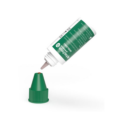 A white-green bottle of Berger Med GmbH Alphacheck Professional Control Solution A+ B | Package (2 bottles), resembling a control solution, is turned upside down with a drop forming at the nozzle. The green cap is placed on the underlying surface. The bottle features a white label with text in green and white.