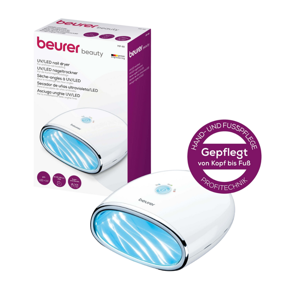 Utgående artikkel Beurer MP 48 LED/UV-neglelampe fra Beurer GmbH står ved siden av emballasjen. Neglelampen er egnet for hånd- og fotpleie samt kunstneglmodellering. På esken er detaljer og merkevare på tysk avbildet.