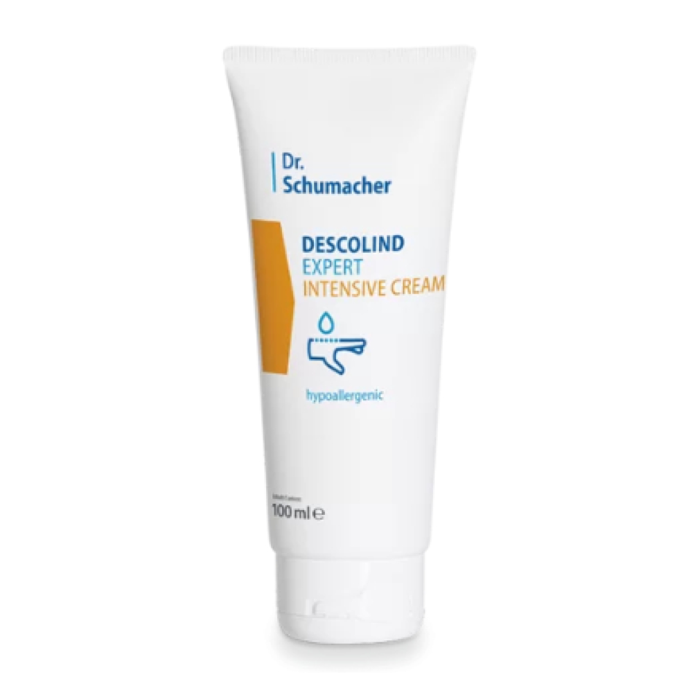 Un tubo blanco con la inscripción «Dr. Schumacher Descolind Expert Intensivcreme | Tube (100 ml)» de Dr. Schumacher GmbH está erguido frente a un fondo sencillo. El empaque presenta un rectángulo amarillo y un símbolo de gota, destacando las propiedades hipoalergénicas, lo que lo hace perfecto para pieles sensibles.
