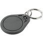A gray, round Novocal transponder key fob for EZERFID (13.56 MHz MifareClassic), with a metal key ring, depicted on a white background. Pack of 10 pieces (1 piece per unit).