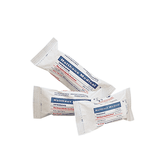 Se exponen tres envases de paquetes de vendajes Holthaus Medical YPSISAVE, estériles, cada uno con rotulación en azul y rojo. El texto del envase es, presumiblemente, en alemán y contiene información sobre el producto. Cada envase está empaquetado y sellado individualmente, lo que indica que se trata de paquetes de vendajes estériles de la empresa Holthaus Medical GmbH & Co. KG.