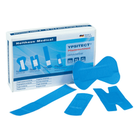 A collection of blue adhesive bandages in various shapes is displayed in front of an open box labeled “Holthaus YPSITECT® Adhesive Bandage Assortment – Detectable – 50 Bandages” by Holthaus Medical GmbH & Co. KG, which contains information in German. This assortment, which is ideal for the food processing industry, includes finger bandages, ankle bandages, and surgical bandages.