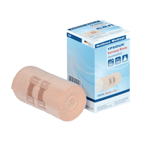 Venda de tracción corta Ypsidur® con clips para vendajes de Holthaus Medical GmbH & Co. KG. La imagen muestra una venda de tracción corta de elasticidad permanente enrollada junto a su caja. La venda, de color beige, está sujeta con dos clips para vendajes del mismo color, y el texto de la caja está redactado principalmente en alemán e incluye detalles del producto.