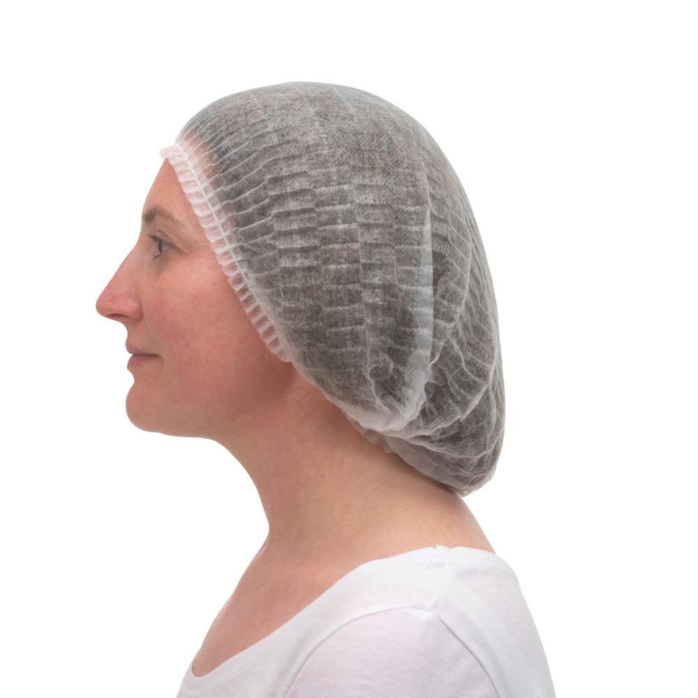 Eine im Profil gezeigte Person mit weißem Oberteil trägt eine Kimberly-Clark GmbH KleenGuard® A10 Leichte Haube mit Gummizug (weiß, Universal). Die Haube bedeckt ihr Haar vollständig; der Hintergrund ist einfarbig weiß.