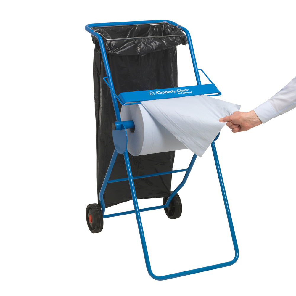 Ein blauer Papierhandtuchspender mit einem schwarzen Müllbeutel ist zu sehen, während eine Hand ein Blatt aus einer WypAll® X60 General Clean Großrolle (1 Rolle x 500 Blatt, Blau) der Kimberly-Clark GmbH herauszieht - ideal für professionelle Reinigungsaufgaben.