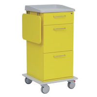 El carrito de cuidados y trabajo Novocal está pintado de amarillo, cuenta con tres cajones con tiradores metálicos, una bandeja lateral abatible, una encimera y un suelo de color gris, así como cuatro ruedas; es ideal para cualquier centro hospitalario moderno.