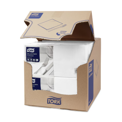 Una caja con servilletas de almuerzo suaves Tork 477414 blancas Advanced de 3 capas está parcialmente abierta y deja ver cuatro pilas de servilletas blancas de tres capas, compostables industrialmente. La caja muestra la marca azul y blanca de TORK - Essity Professional Hygiene Germany GmbH, junto con información del producto y una clara instrucción de "Abrir aquí" en la tapa superior.