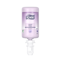A clear bottle of Tork luxury liquid soap from Essity Professional Hygiene Germany GmbH, labeled “Luxury” and “Gentle on the Skin,” enriched with magnolia extract. The soap is purple and is part of the S4 system; it has a dispensing nozzle on the bottom and holds 1000 ml.