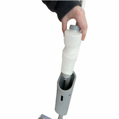 A person inserts a white cleaning solution bottle into the handle of the Arcora Ultra Mobile Spray Mop System by Arcora International GmbH on a white background.