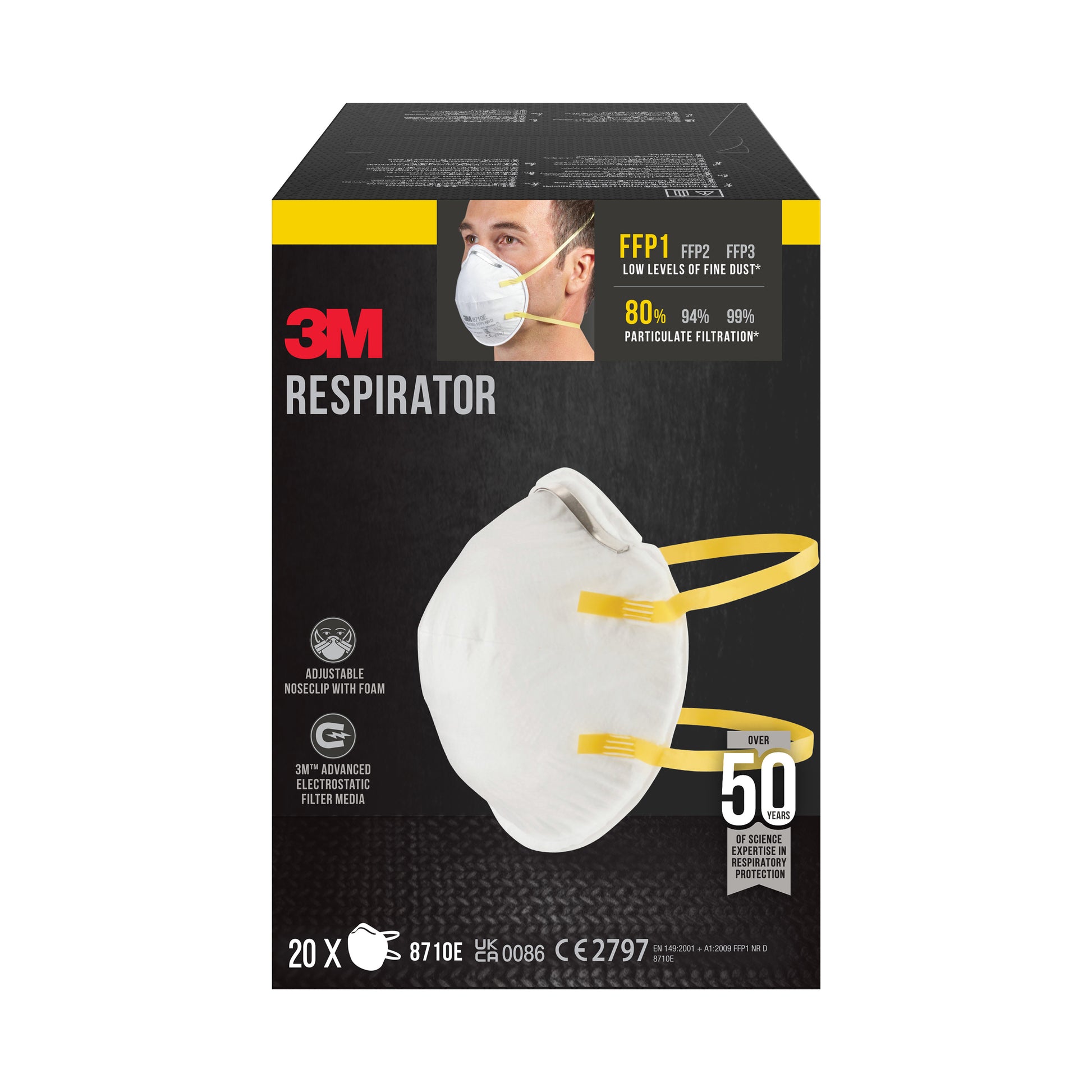 Eine Schachtel der 3M™ Partikelmaske 8710E der 3M Deutschland GmbH, FFP1 ohne Ventil, zeigt eine weiße Maske mit gelben Bändern und eine Person, die sie trägt. Auf der Schachtel sind 20 Masken und eine Partikelfiltrationseffizienz von ≥80 % angegeben.