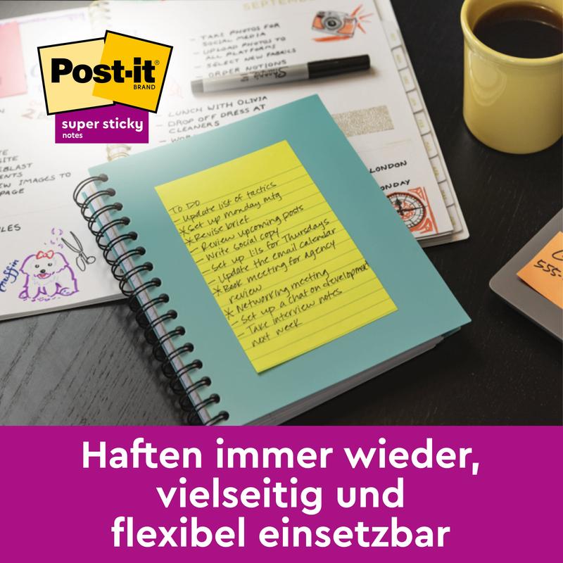 A yellow, lined Post-it® Super Sticky Note (large format, 101 mm x 152 mm) from 3M Deutschland GmbH sticks on a teal notebook on the desk. It is versatile, reusable, and comes in 3-packs with PEFC-certified paper.