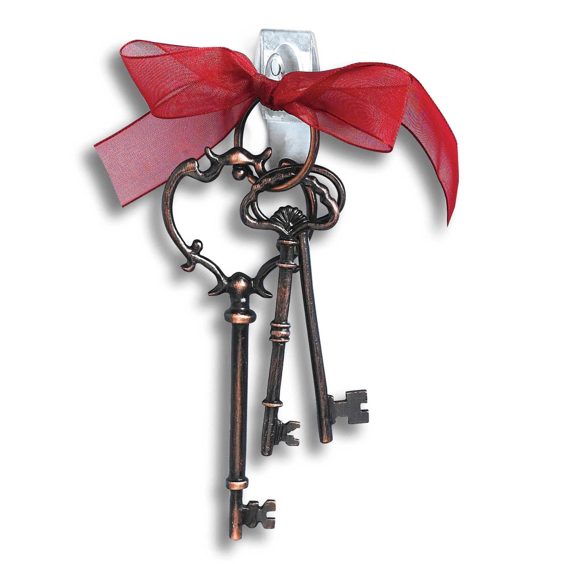 Zwei verzierte Metallschlüssel im Vintage-Stil, gebunden mit einem roten, durchsichtigen Band, hängen an einem 3M Command™ Mini-Haken, transparent (17006CLRFGN), der auf einem weißen Hintergrund angebracht ist.