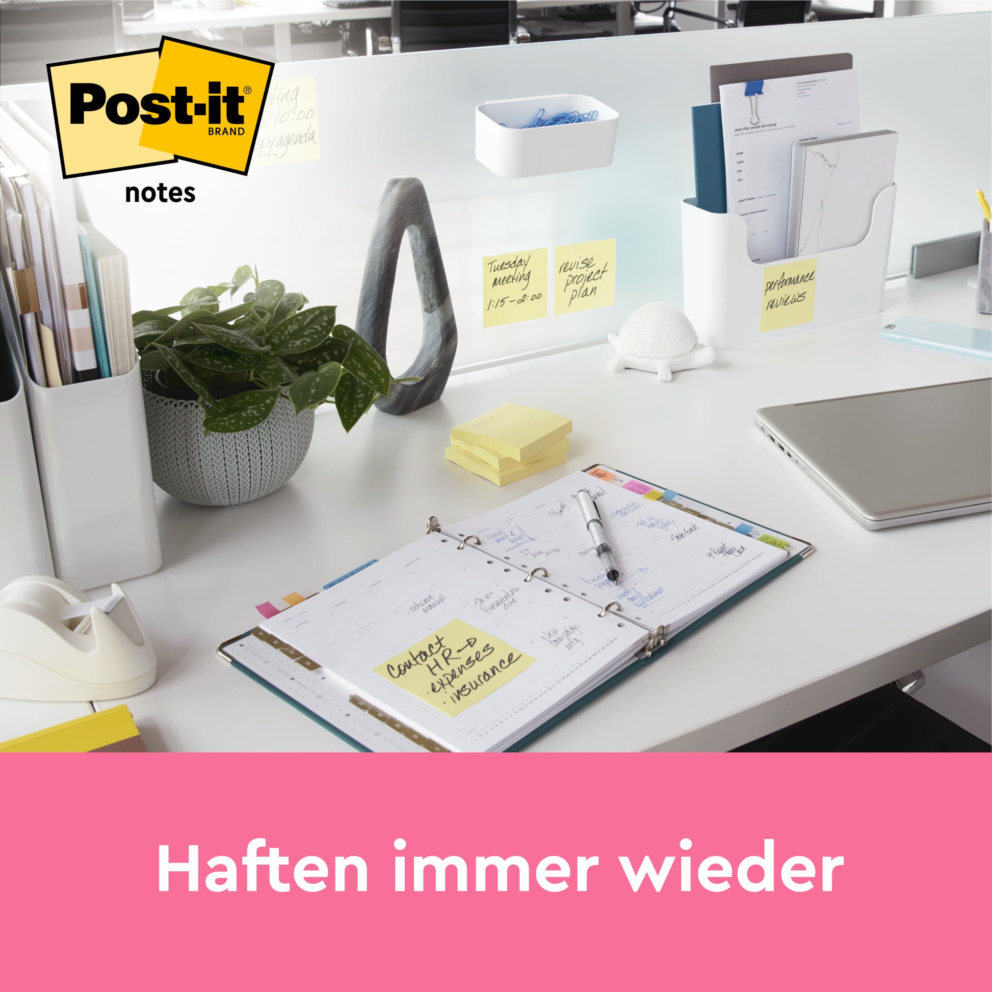 Ein aufgeräumter Schreibtisch mit Büromaterial, einer Pflanze, einem Laptop, einem aufgeschlagenen Planer mit Notizen und mehreren Post-it® Notes (Gelb, 76x102 mm) der 3M Deutschland GmbH auf einem Trennblatt. Darunter ein rosa Banner: "Haften immer wieder.