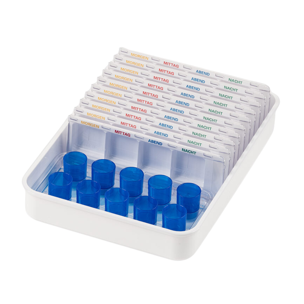 Et hvitt Melipul dispenser-/kopp-brett fra Helmut Schwarz GmbH inneholder flere gjennomsiktige pilledispensere, en del av et medikamentorganisasjonssystem, merket med norske ord for tid på dagen: «Morgen», «Middag», «Kveld», «Natt». Hver gjenbrukbare dispenser har spor for piller og blå lokk på den ene siden.